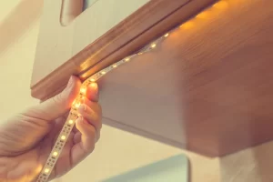 A-Person-Installing-Led-Strip-Lights-in-Cabinet